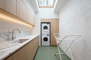 Ljus och modern tvättstuga med tvättmaskin och torktumlare