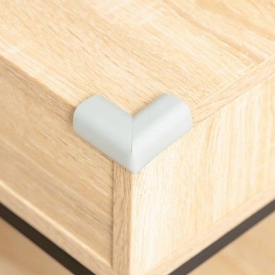 Grått hörnskydd monterat på en ljus trämöbel för säker transport.